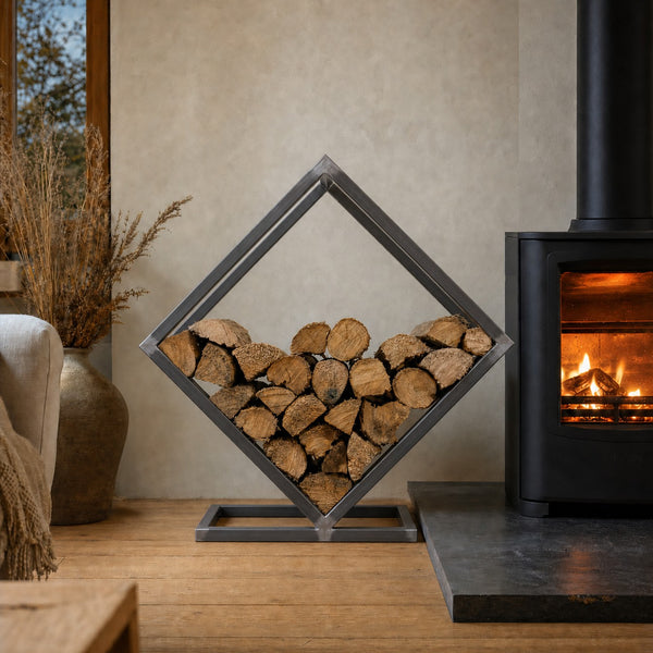 Kirkstone Diamond Log Store in raw steel beside a wood burner