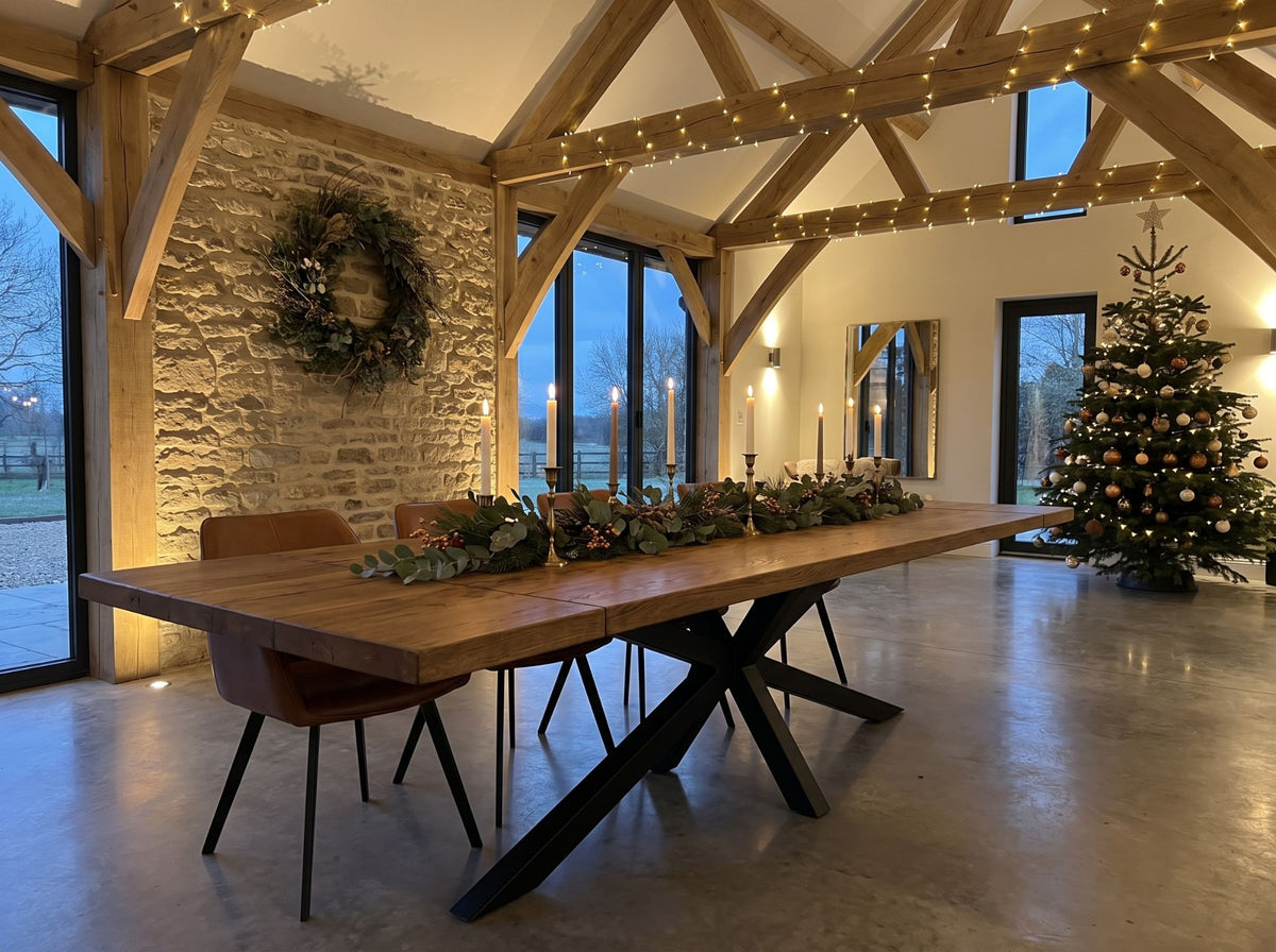 Reclaimed elm dining table with spider legs, laid for Christmas in an oak-beamed barn